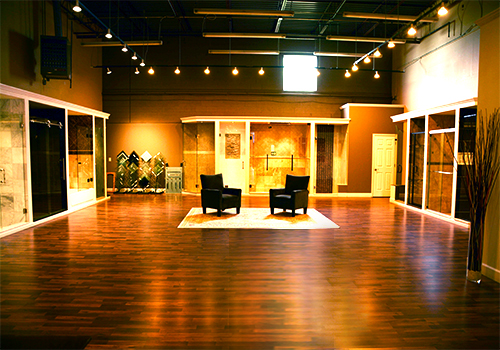 L&L Glass showroom - a large room with two chairs and models of shower doors along the walls.