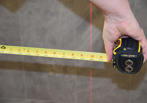 Hand holding an extended tape measure