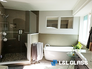 Stand alone tub and glass shower enclosure in updated bathroom with polished nickel fixtures.