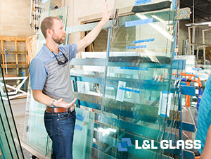 L&L Glass employee standing in front of fabricated glass ready for installation